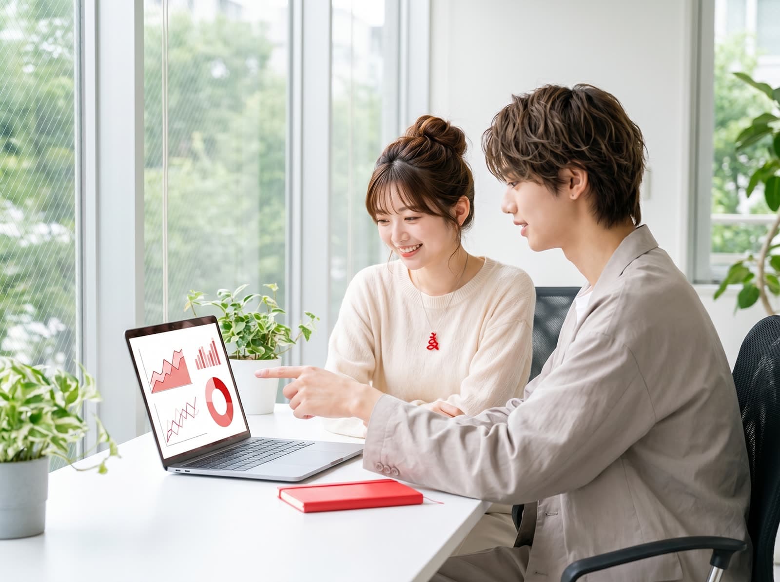 ノート PC に映したグラフを、二人で見ながら話している様子